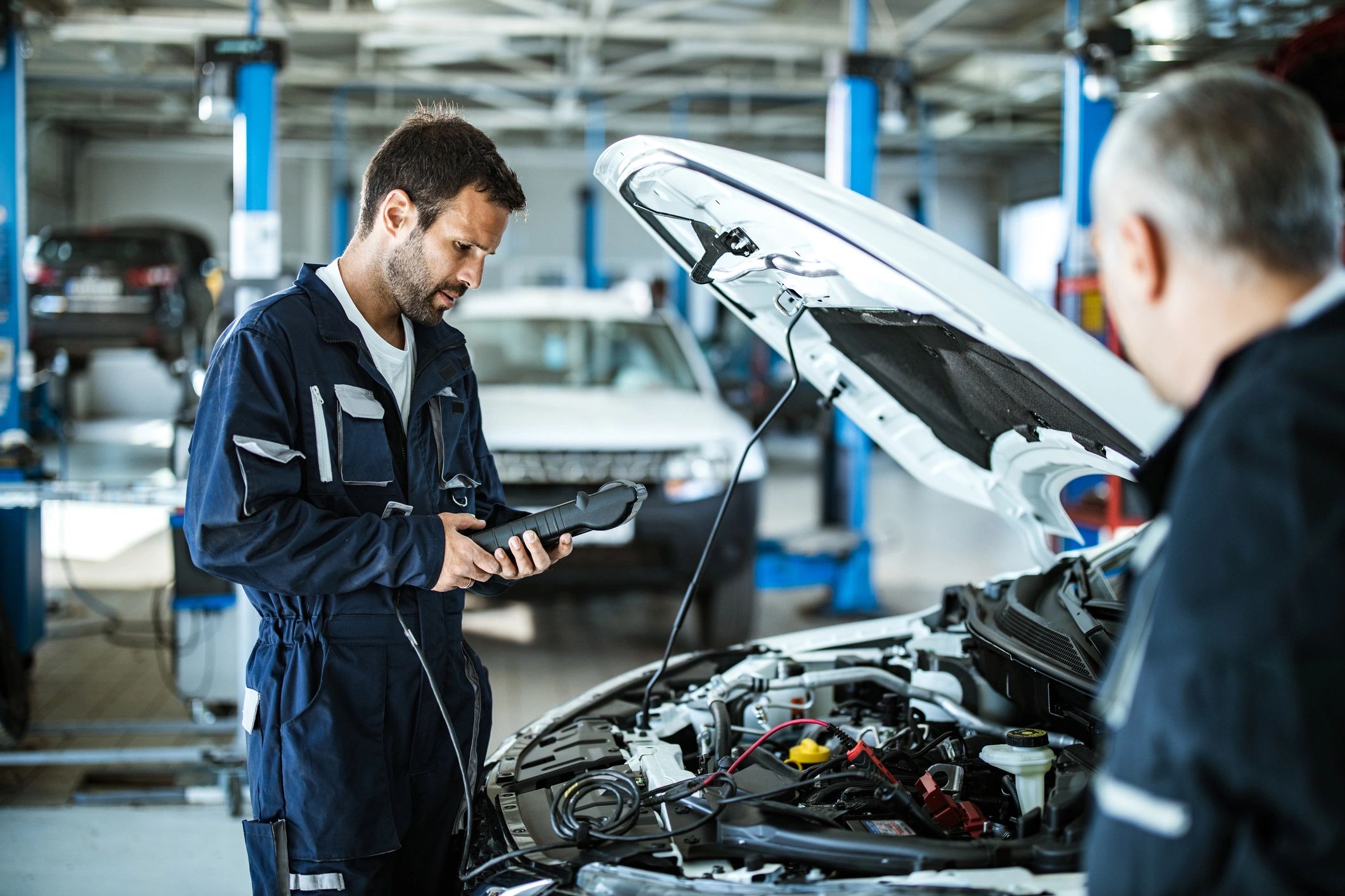 Mechanic using a diagnostic tool in a workshop