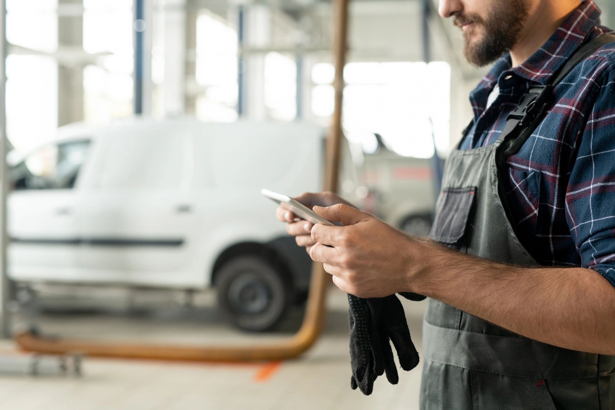 Technician in a workshop using a tablet for vehicle service documentation