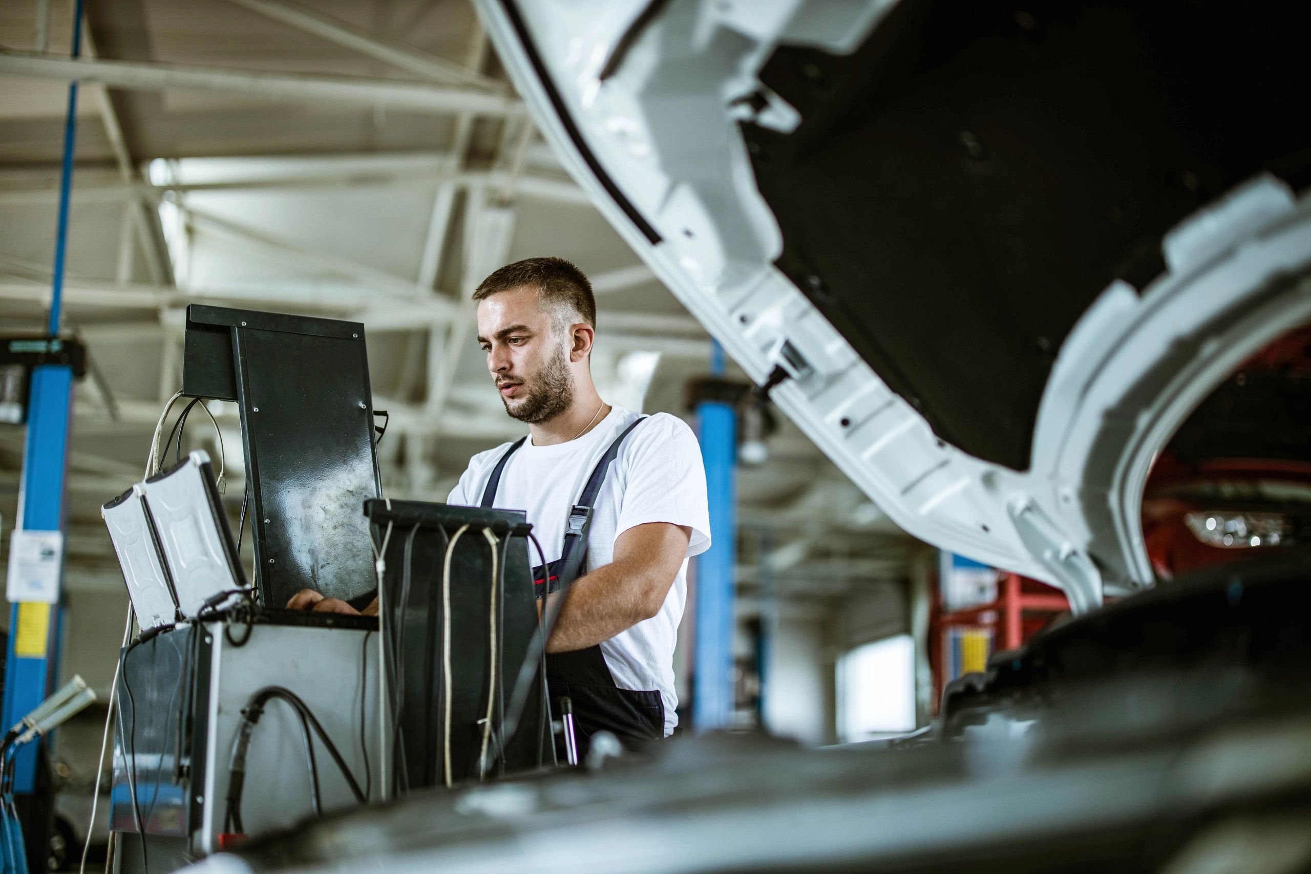 Mechanic using a computer for vehicle diagnostics in a repair shop