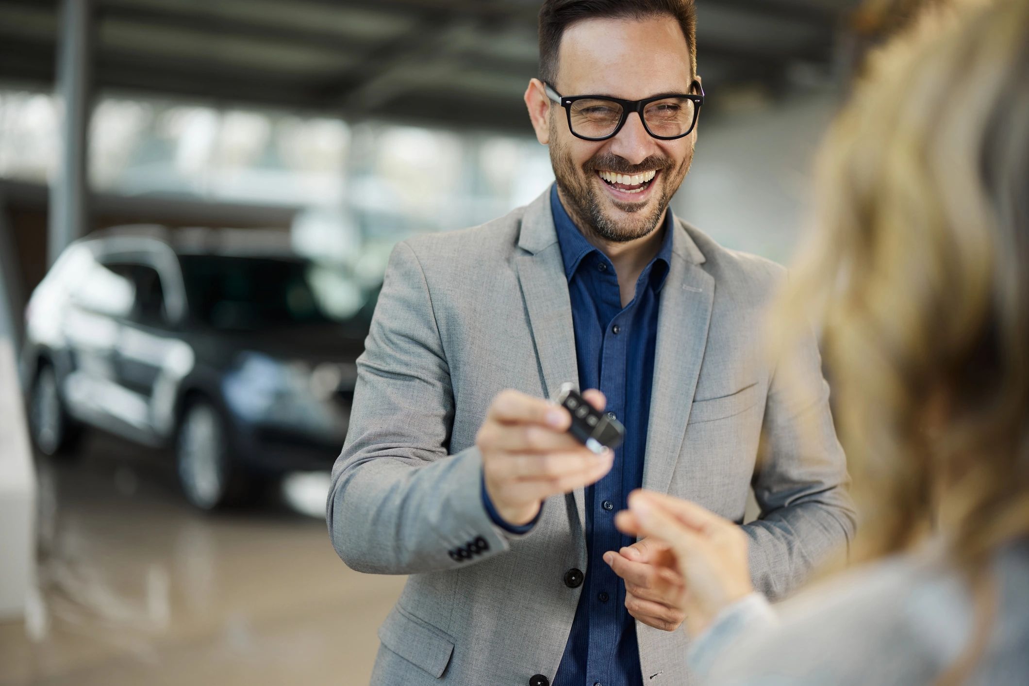 Smiling customer receiving car keys