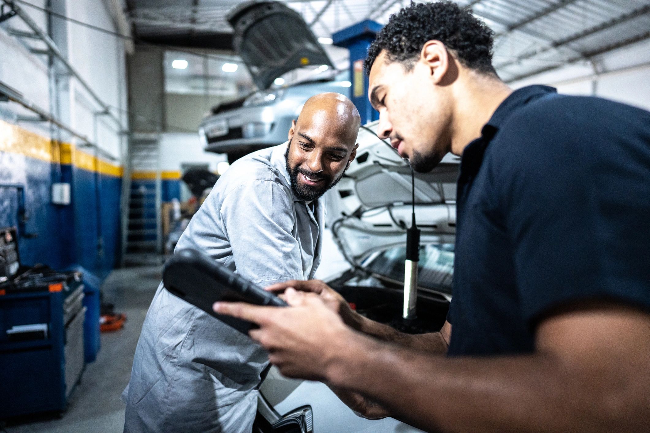 Two mechanics discussing a repair in an auto shop