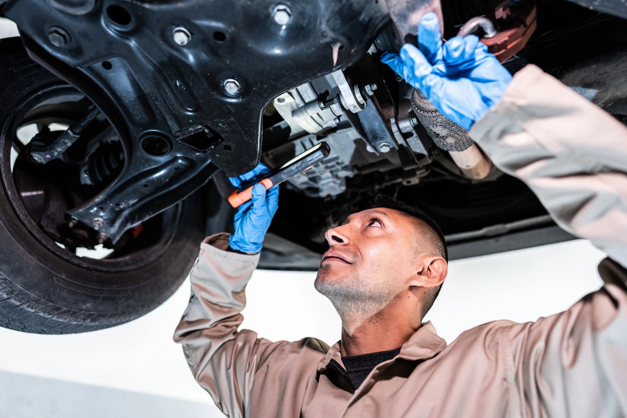 Mechanic working under a vehicle in a repair shop